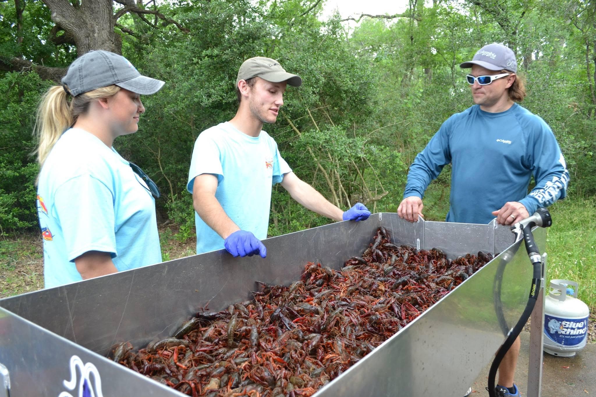 AFL volunteers preparing crawfish in large boiling pot outdoors