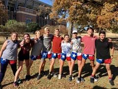 Group photo of participants in running gear, wearing blue shorts and showing enthusiasm