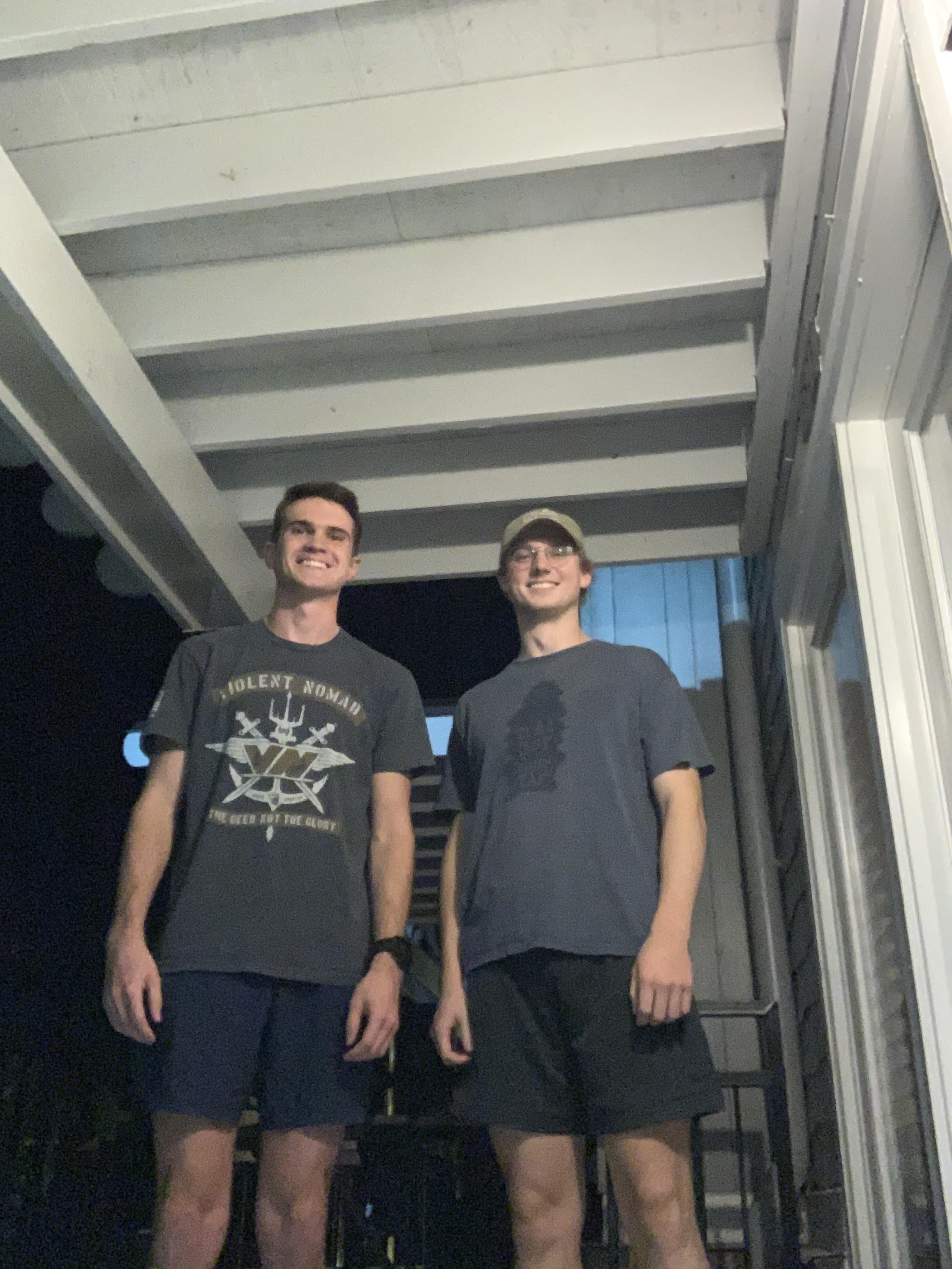 Two AFL members in athletic wear posing under covered walkway during evening walkathon participation