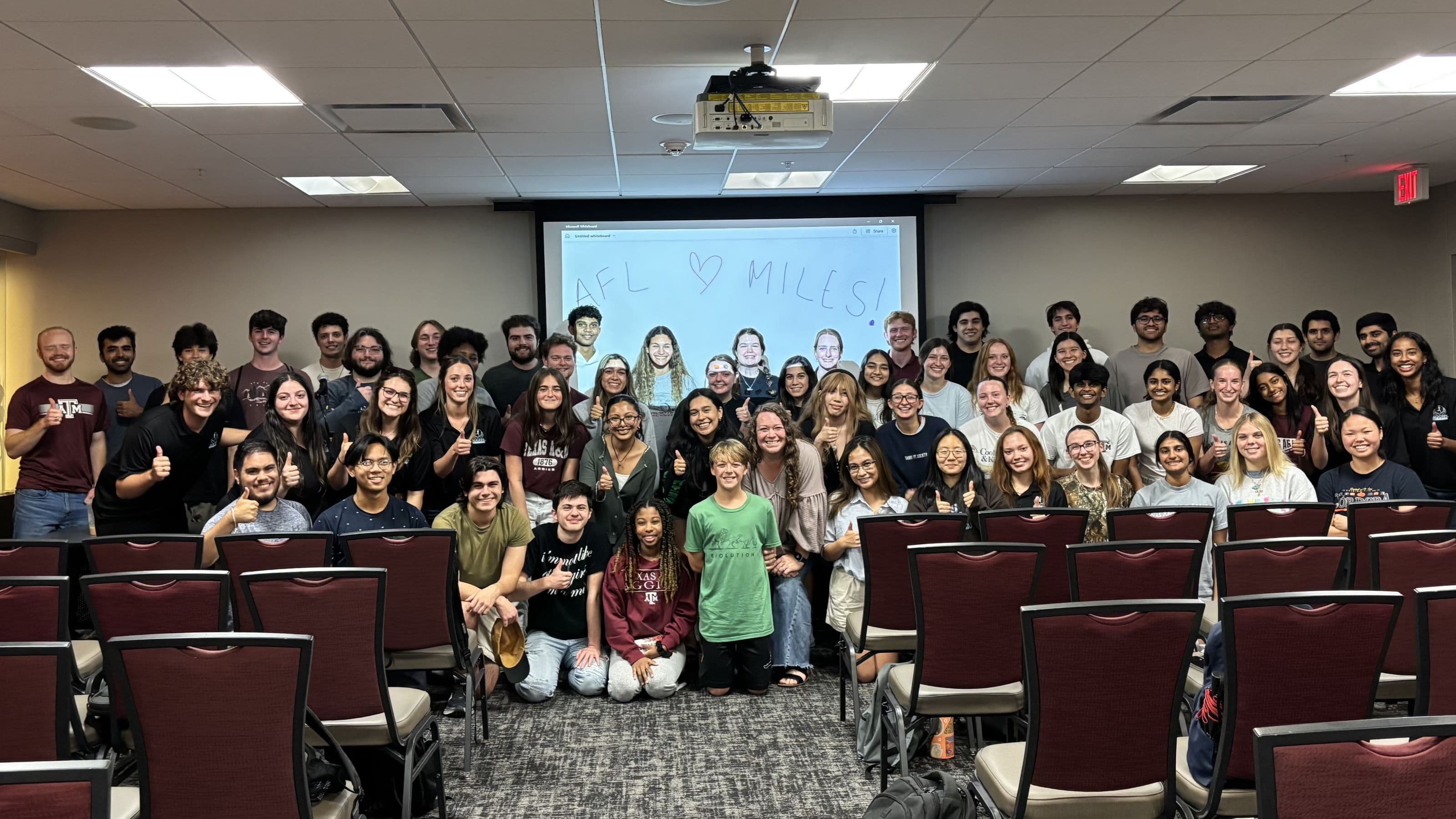 Large group of Aggies for Limbs members at a meeting venue, showing enthusiasm with thumbs up gestures with one of their Angels